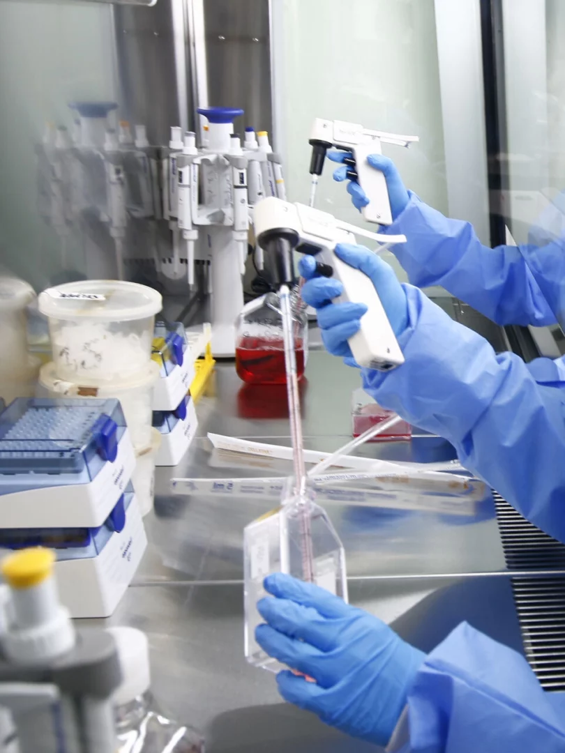 cientists in a laboratory using advanced equipment for research, wearing personal protective equipment and handling precision tools.